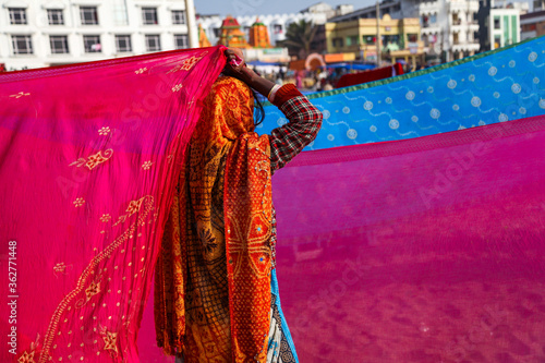 Indian women pilgrims drying their colorful sarees under sun after taking holy bath at puri beach. photo