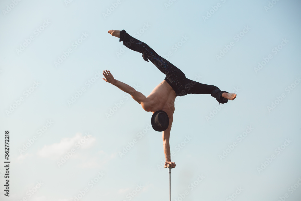 Fototapeta premium performance of an aerialist outdoors during sunset.