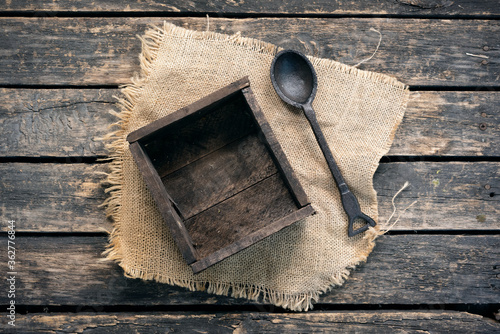 Wooden container box and spoon on old wooden table background.