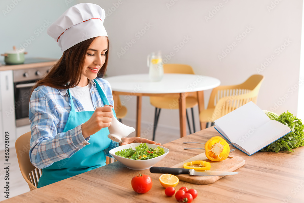 Young woman making tasty salad in kitchen Young woman making tasty salad in kitchen