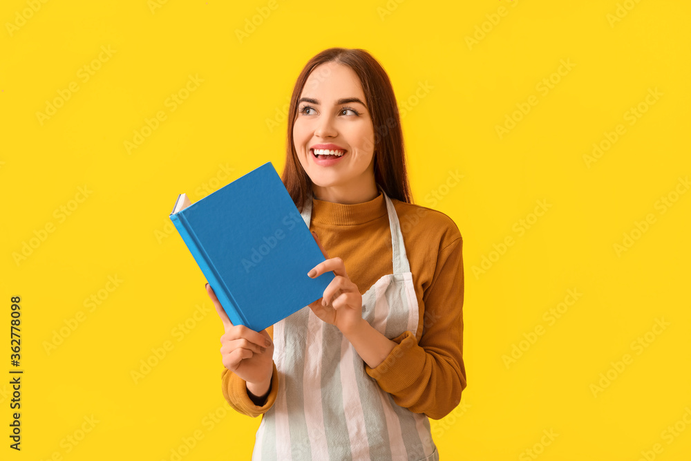 Young woman with recipe book on color background Young woman with recipe book on color background