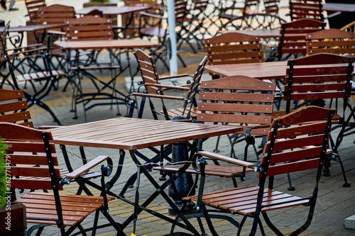 Empty chairs and tables in an outdoor cafe or restaurant on a summer day