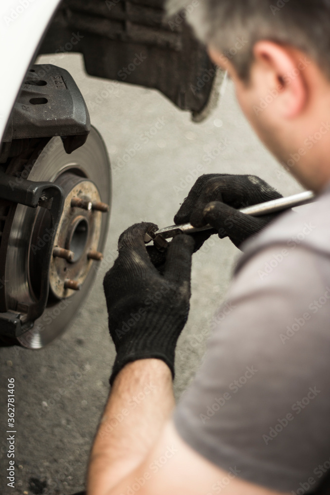 Obraz premium mechanic changing car tire