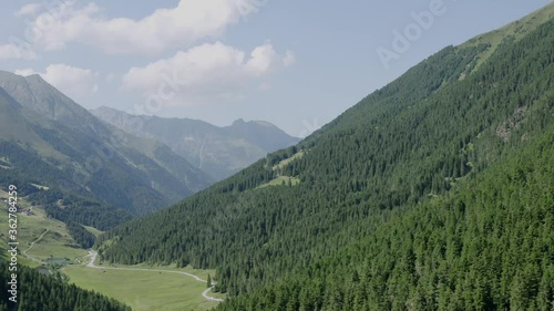 Ariel tracking overlooking Sellrain, Austrian Alps on a clear with surrounding pines throughout the valley photo