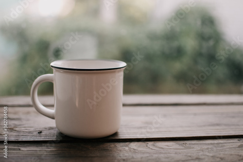 White vintage mug on the wooden table.