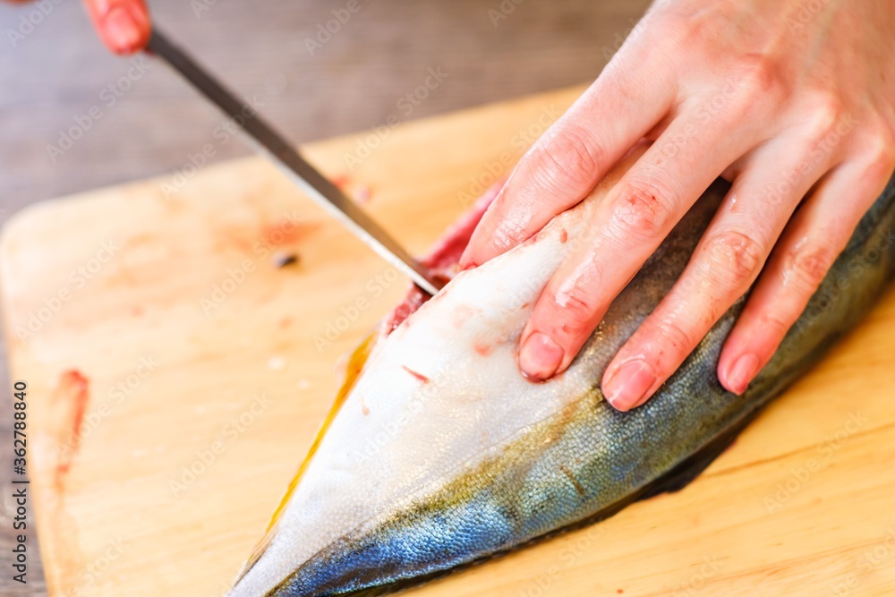 Cutting raw fish tuna food, seafood meal.