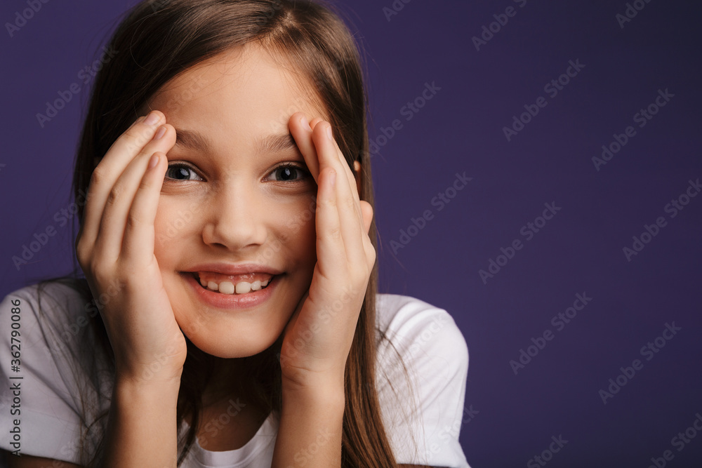 Photo of cheerful girl covering her face and looking at camera