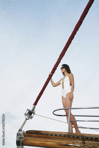 Woman in swimsuit standing at the edge of a yacht