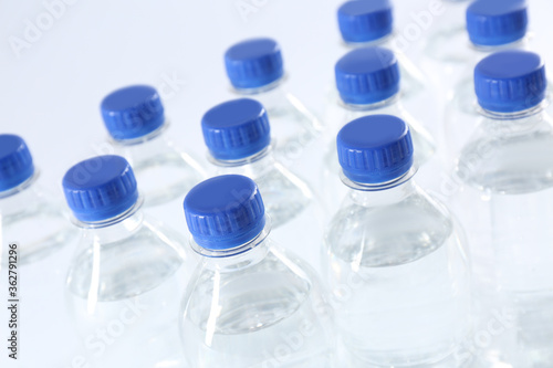 Plastic bottles with pure water on white background, closeup