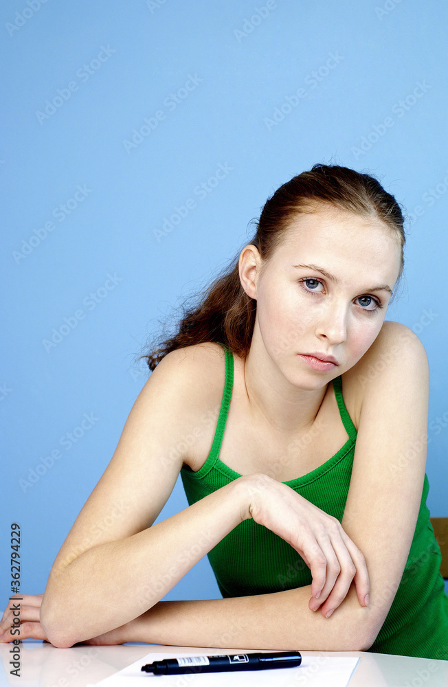 Woman sitting with a pen and a paper on the table Woman sitting with a pen and a paper on the table