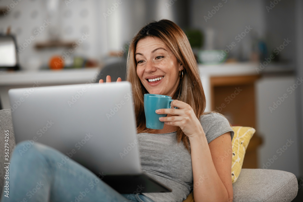 Beautiful woman having a video call on a laptop. Young woman enjoying at home.
Beautiful woman having a video call on a laptop. Young woman enjoying at home.