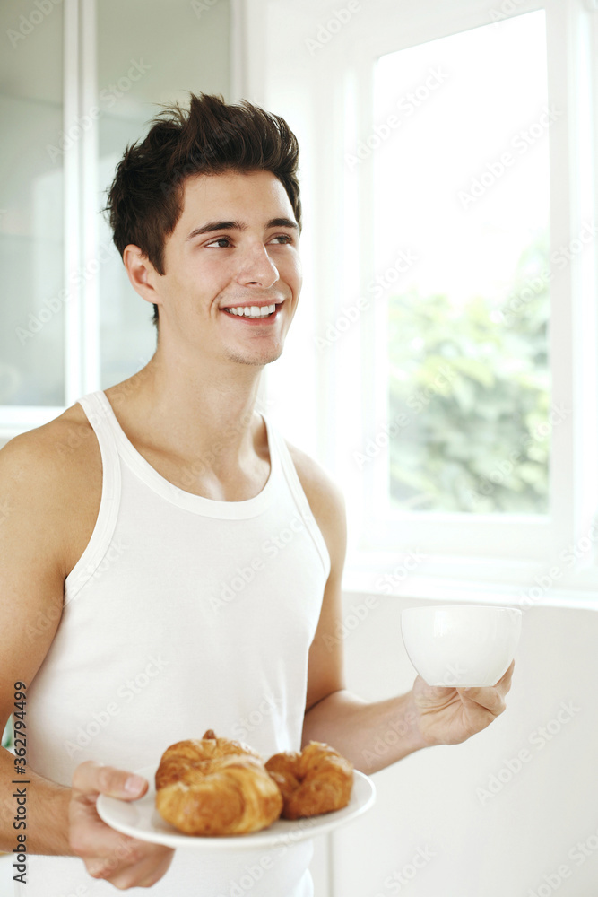 Man with a cup of coffee and a plate of croissants Man with a cup of coffee and a plate of croissants