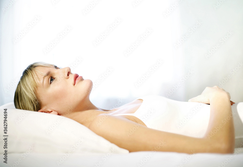 Obraz premium Woman lying on the bed thinking