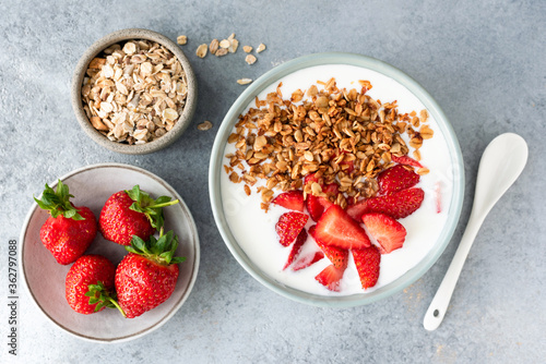 Yogurt with strawberries and granola in bowl. Homemade granola with fresh strawberries and natural greek yogurt. Healthy breakfast food top view