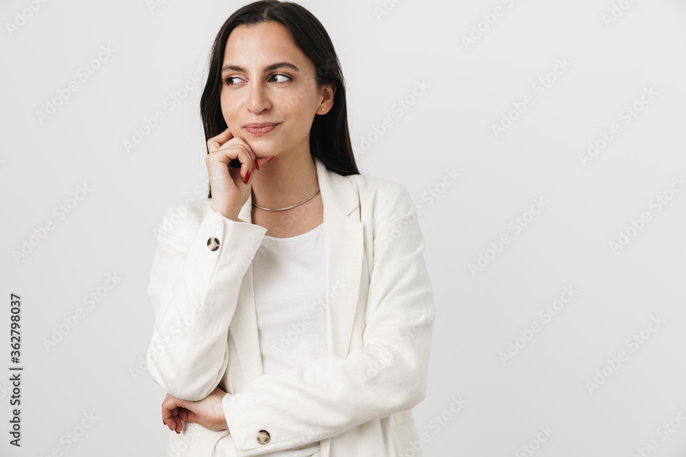 Photo of pleased attractive businesswoman thinking and looking aside Photo of pleased attractive businesswoman thinking and looking aside