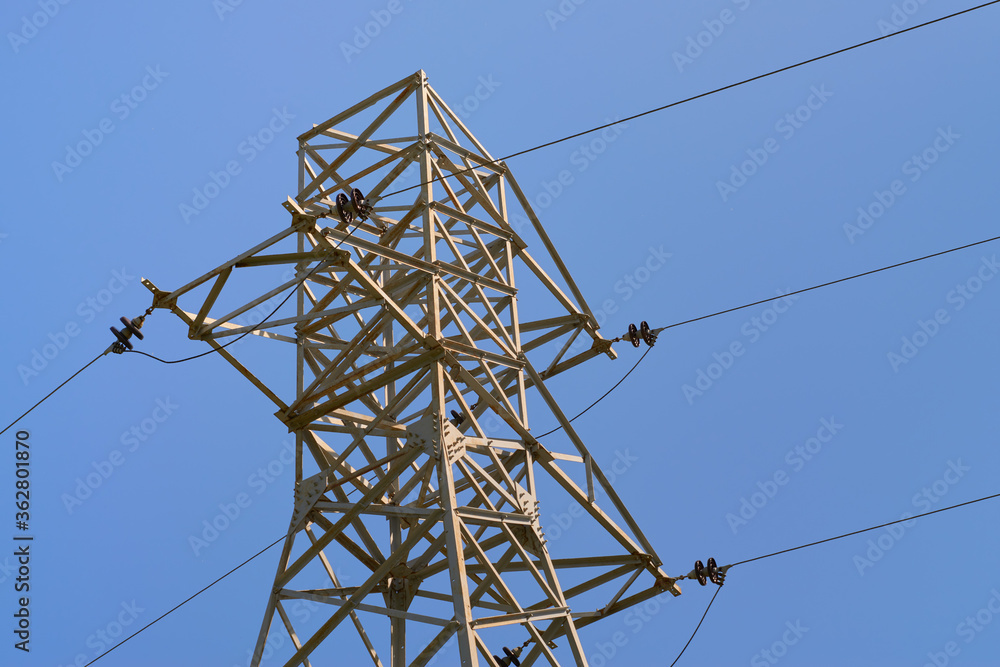 Part of the support of the power line, illuminated by the sun against the sky Part of the support of the power line, illuminated by the sun against the sky