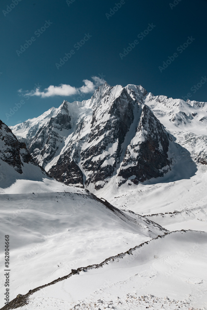 Hiking on the Snowfields of Indian Himalayas with the high altitude panoramic view of higher mountains in mountaineering