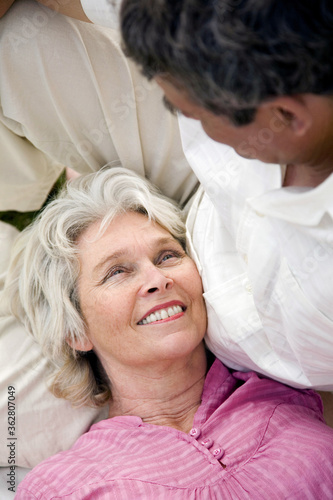 Senior woman lying on senior man's lap