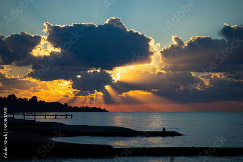 Seascape with a bright sunset and rays through the clouds