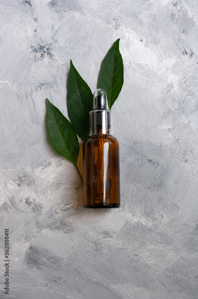 Natural cosmetics glass dropper with green leaves.Copy space for text. Natural care. Aromatherapy Natural cosmetics glass dropper with green leaves.Copy space for text. Natural care. Aromatherapy