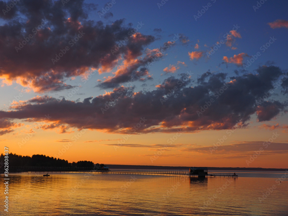 Sunset, summer, beautiful clouds at sunset. Pier on the big Kama river. Ural, Russia, Perm Territory, Elovo. Sunset, summer, beautiful clouds at sunset. Pier on the big Kama river. Ural, Russia, Perm Territory, Elovo.
