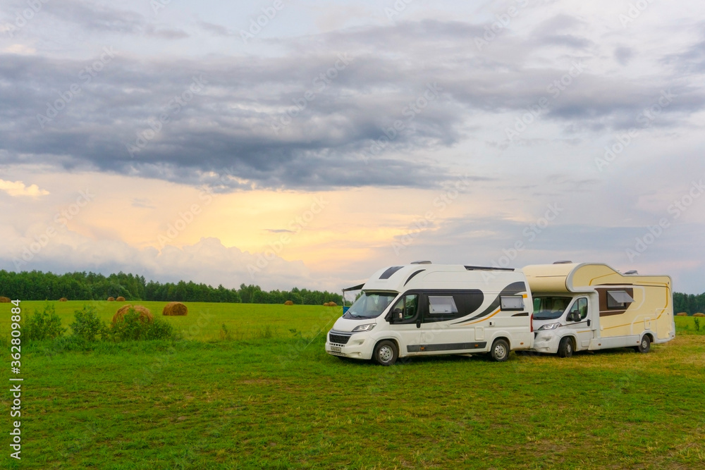 Family vacations and traveling (trip) outdoors by motorhome (сaravan car). Two motorhomes in a summer camp outdoors. Travel (trip) by car concept.
