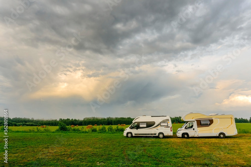Family vacations and traveling (trip) outdoors by motorhome (сaravan car). Two motorhomes in a summer camp outdoors. Travel (trip) by car concept.