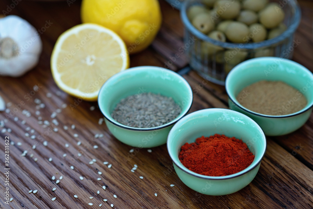 Oriental spices cumin, ground zira and red pepper paprika in bowls on a wooden oak table. Soft selective focus. Oriental spices cumin, ground zira and red pepper paprika in bowls on a wooden oak table. Soft selective focus.