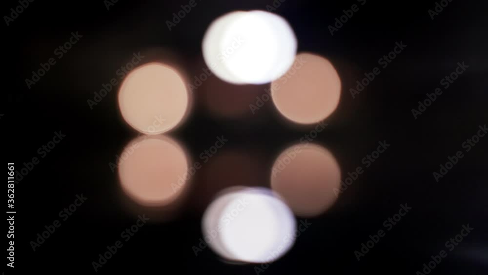 Abstract reflections on the surface of the water. Reflections of lanterns in the pool. Colored glowing spots in the dark. Light ripples on the surface of the water reflect light. Beautiful bokeh light Abstract reflections on the surface of the water. Reflections of lanterns in the pool. Colored glowing spots in the dark. Light ripples on the surface of the water reflect light. Beautiful bokeh light
