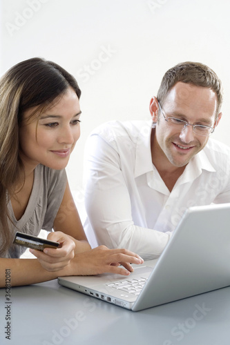 Man and woman using credit card to purchase product online