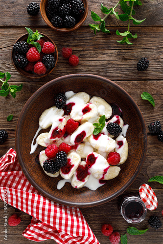 Lazy dumplings, vareniki with fresh berries. Boiled cottage cheese gnocchi with sour cream, raspberry and blackberry. Traditional ukrainian cuisine