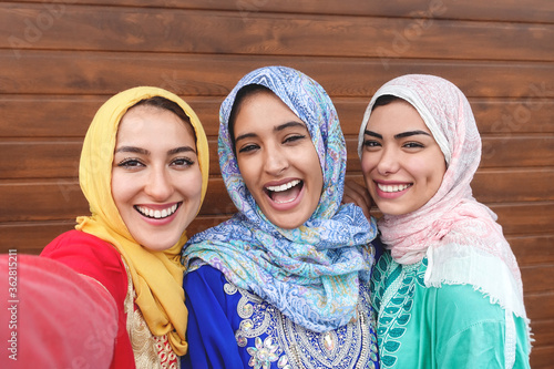 Canvas Print Happy Muslim girls taking selfie outdoor - Arabian young friends portrait making
