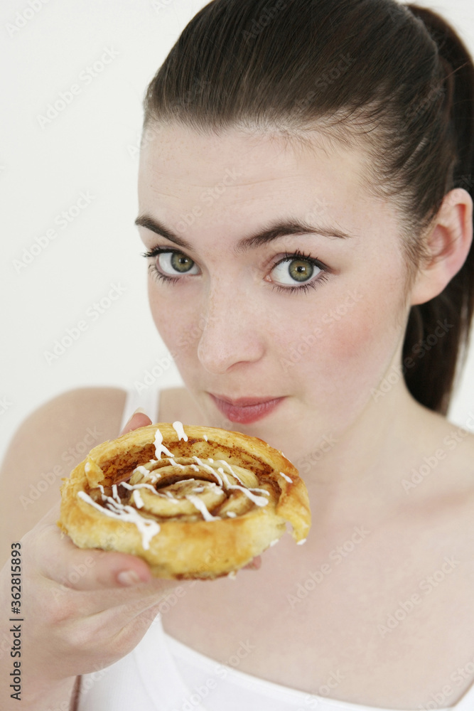 Woman eating cinnamon roll
