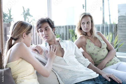 Fotografie Woman touching man, another woman watching