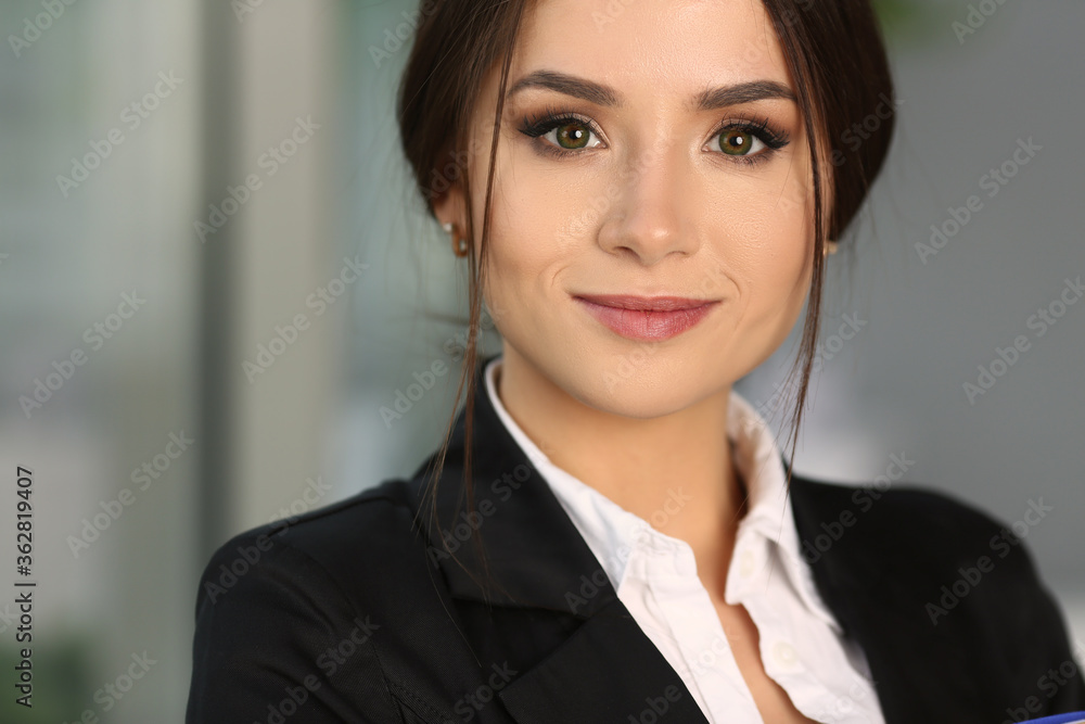Close up of happy beautiful businesswoman wearing black jacket and staying in the office while smiling Close up of happy beautiful businesswoman wearing black jacket and staying in the office while smiling