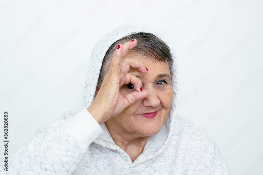 Funny grandma's portraits. The old lady makes a hipster the hand gestures. Fashion hipster woman having fun. Funny moments with a granny woman. Lifestyle and people concepts Funny grandma's portraits. The old lady makes a hipster the hand gestures. Fashion hipster woman having fun. Funny moments with a granny woman. Lifestyle and people concepts