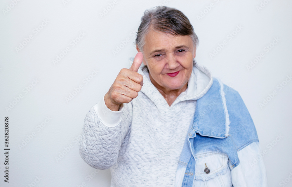 Funny grandma's portraits. An elderly lady makes a hipster gesture with her hand Funny grandma's portraits. An elderly lady makes a hipster gesture with her hand