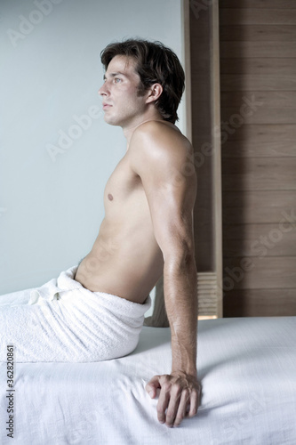 Man in towel sitting on massage table