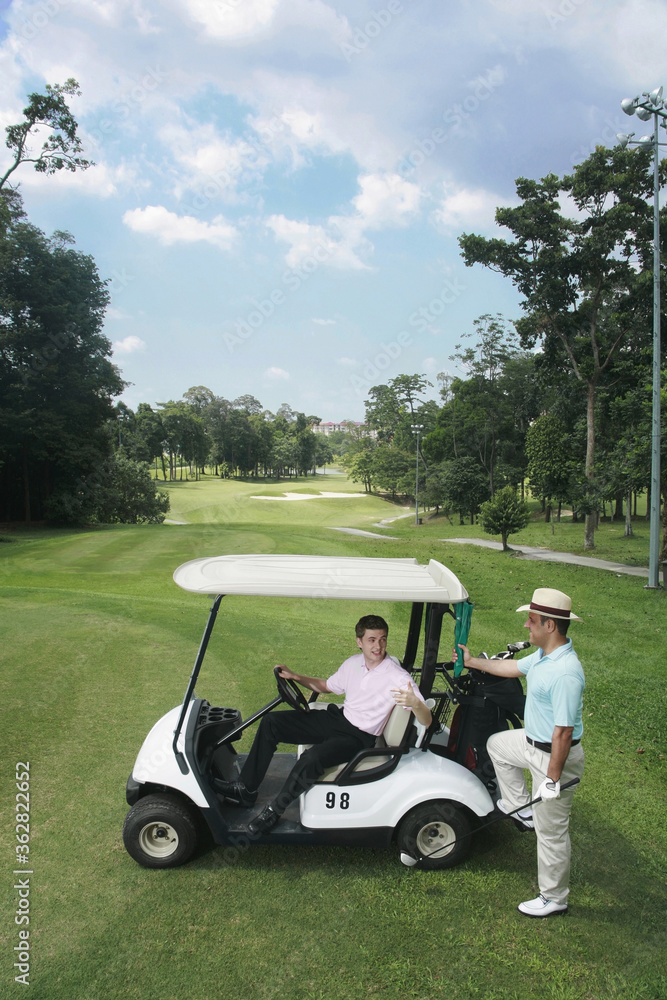 Man in golf cart talking to his friend Man in golf cart talking to his friend