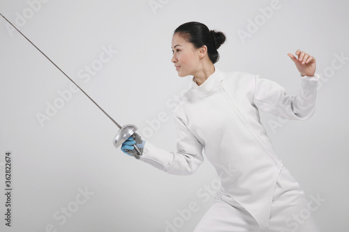 Woman in fencing suit with fencing foil