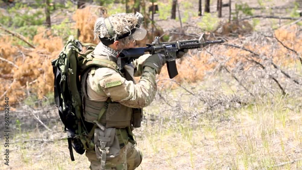 Fully armed american soldier on military range in active war game Airsoft shoots at the target Fully armed american soldier on military range in active war game Airsoft shoots at the target