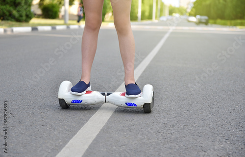Girl child rides a hoverboard dangerously on the road, violation of the rules