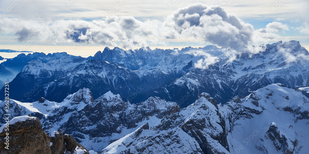 Winter panoramic view of the high mountains and clouds in the Dolomites Alps in Italy.