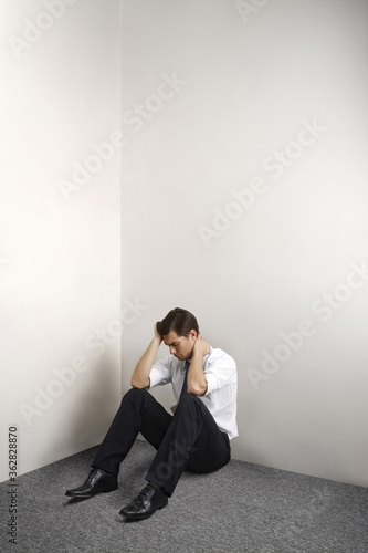 Depressed businessman sitting on the floor alone