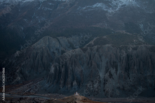 Buddhist stupa with prayer flags in front of massive mountain, Annapurna circuit, Nepal photo