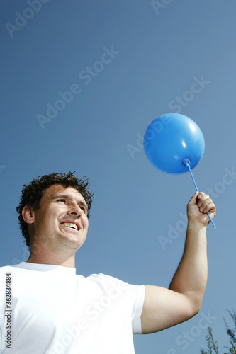 Man holding a blue balloon © ImageHit