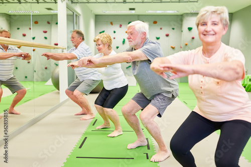 Group of vital seniors doing squats
