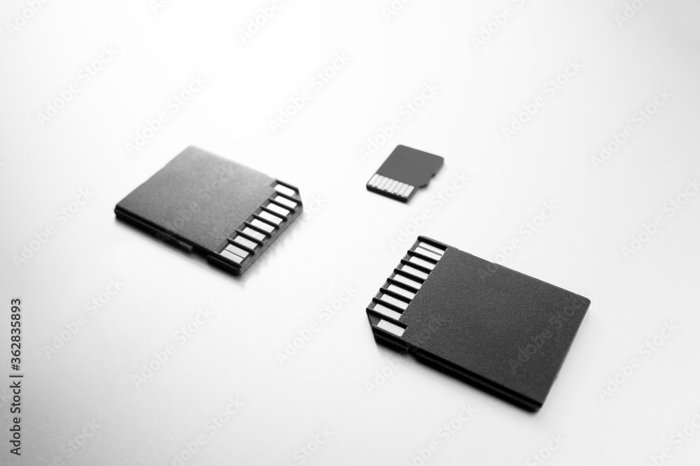 Close-up of three flash cards, technology products, selective focus. memory cards on a white table Close-up of three flash cards, technology products, selective focus. memory cards on a white table