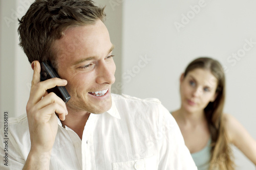 Woman watching her boyfriend talking on the phone