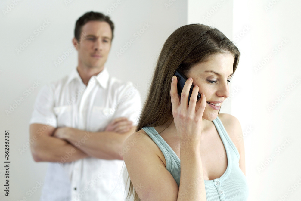 Man watching his girlfriend talking on the phone Man watching his girlfriend talking on the phone